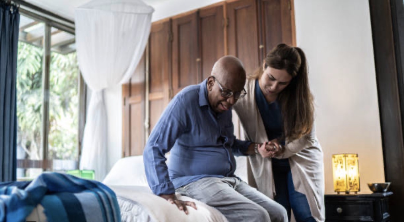 Caregiver assisting senior with movement at home